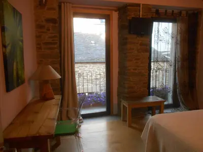 a bedroom with a bed and a large window at XARDÍN DE ESTRELAS *** in Sarria