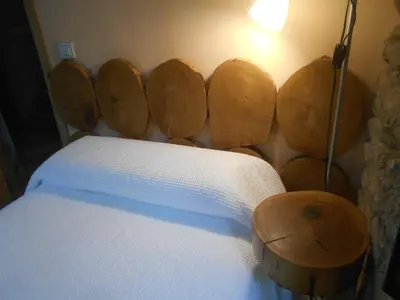 a bedroom with a bed with wooden logs on the wall at XARDÍN DE ESTRELAS *** in Sarria