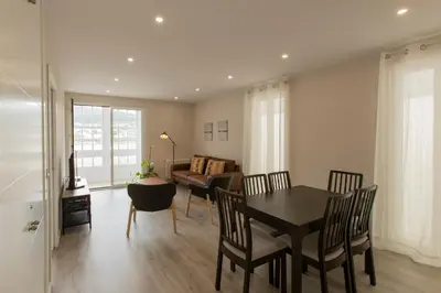 a living room with a table and chairs and a couch at Noray Apartamentos Viveiro in Viveiro