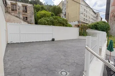 an empty parking lot with a white fence at Noray Apartamentos Viveiro in Viveiro