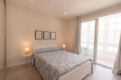 a bedroom with a bed and a large window at Noray Apartamentos Viveiro in Viveiro