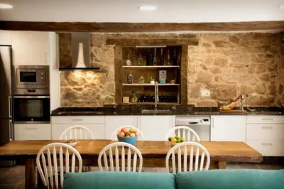 a kitchen with a wooden table and chairs at Casa de Anamá in Entrecinsa