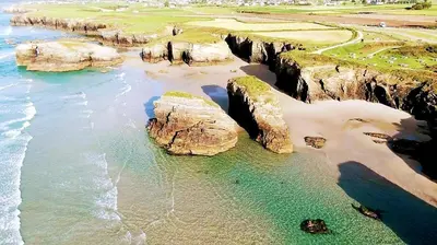 an aerial view of a beach with rocks and the ocean at Playa Catedrales Village in Barreiros
