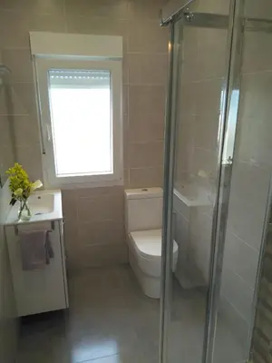 a bathroom with a toilet and a shower and a window at Playa Catedrales Village in Barreiros