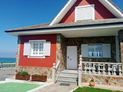 a red house with the ocean in the background at Playa Catedrales Village in Barreiros