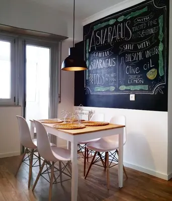 a dining room with a table with chairs and a chalkboard at Amplio apartamento a 5 minutos del centro in Lugo