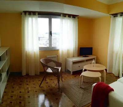 a room with a bed and a desk and a window at Amplio apartamento a 5 minutos del centro in Lugo
