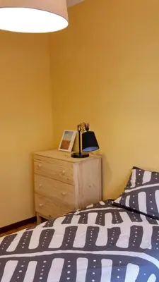 a bedroom with a bed and a dresser with a lamp at Amplio apartamento a 5 minutos del centro in Lugo