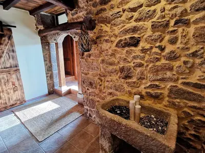 a stone wall with a stone sink in a room at Apartamentos Casa do Bouza Vello in Sober
