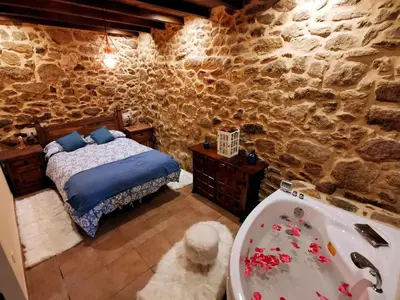 a bedroom with a bed and a bath tub at Apartamentos Casa do Bouza Vello in Sober