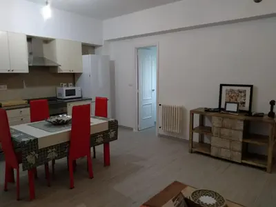 a kitchen and dining room with a table and red chairs at APARTAMENTO EN EL CENTRO DE LALIN in Lalín