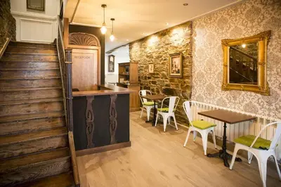 a room with a staircase and a table and chairs at Hotel portico in Fonsagrada