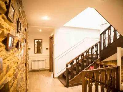 a hallway with a staircase and a stair case at Hotel portico in Fonsagrada