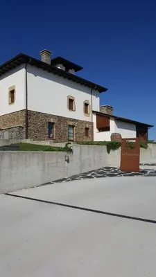 a large white building with a brick at Hotel Rural La Sobreisla in Puerto de Vega