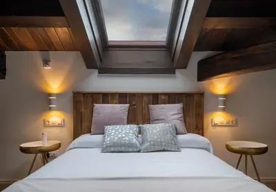 a bedroom with a large bed with a wooden headboard at Hotel Rural La Sobreisla in Puerto de Vega