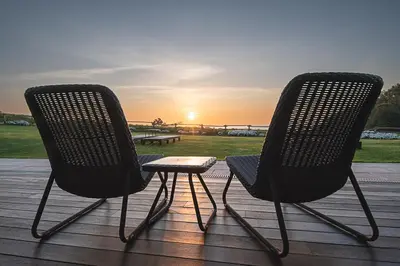 two chairs sitting on a deck watching the sunset at Hotel Rural La Sobreisla in Puerto de Vega