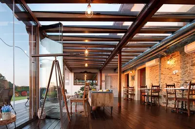 an open living room with a table and chairs at Hotel Rural La Sobreisla in Puerto de Vega