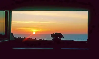 a view of a sunset from a window at Hotel Rural La Sobreisla in Puerto de Vega