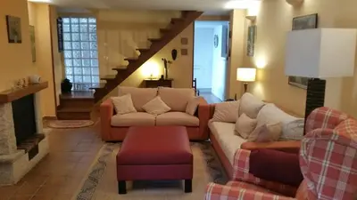 a living room with two couches and a staircase at A CASA DO BUXO in Nogueira de Ramuin