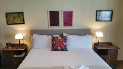 a bedroom with a white bed with two tables and two lamps at A CASA DO BUXO in Nogueira de Ramuin