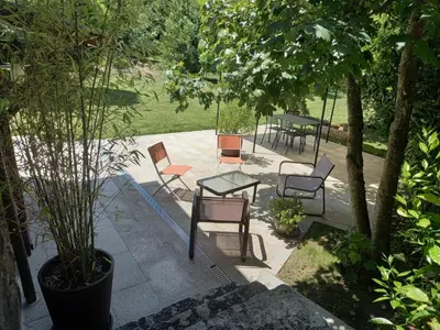 a patio with chairs and a table in a park at A CASA DO BUXO in Nogueira de Ramuin