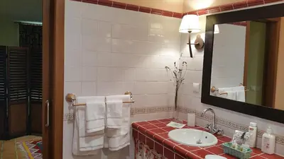 a bathroom with a sink and a mirror and towels at A CASA DO BUXO in Nogueira de Ramuin