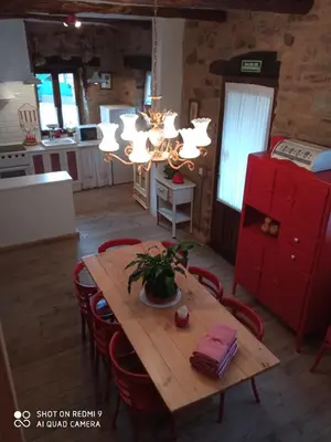 a kitchen with a wooden table with chairs and a chandelier at Casa rural Nica in Arganza