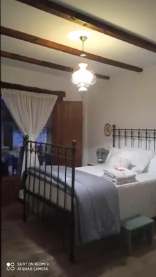 a bedroom with a large bed with a lamp at Casa rural Nica in Arganza
