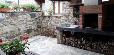 a stone building with a fireplace and a stone wall at Casa rural Nica in Arganza
