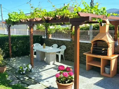 a wooden pergola with a table and a pizza oven at Apartamentos Turísticos Rosa in Ribadeo