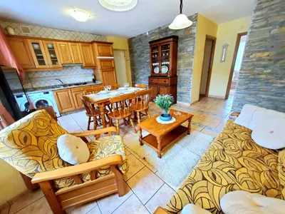 a kitchen and living room with a table and chairs at Apartamentos Turísticos Rosa in Ribadeo
