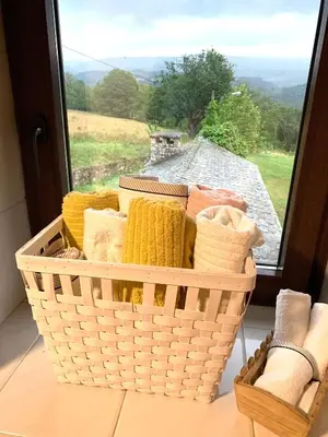 a basket of towels sitting on a table next to a window at FINCA SALVADOR in Baralla