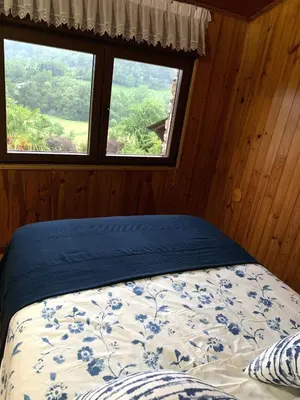 a bed in a room with two windows at FINCA SALVADOR in Baralla