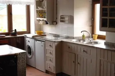 a kitchen with a sink and a washing machine at FINCA SALVADOR in Baralla
