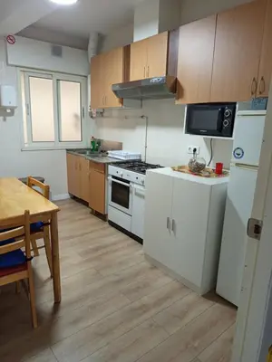 a kitchen with white appliances and a wooden floor at Pensión Fornos in Caldas de Reis