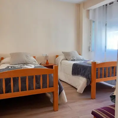 a bedroom with two beds and a window at Pensión Fornos in Caldas de Reis
