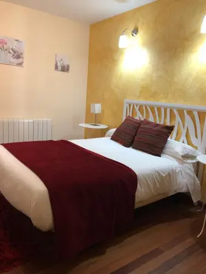 a bedroom with a large white bed with brown pillows at Hotel gela in El Puente