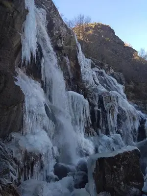 a waterfall on the side of a mountain with snow at Hotel gela in El Puente