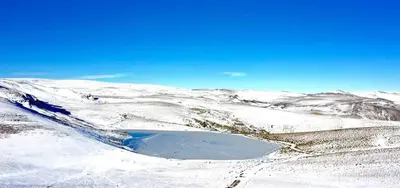 a lake in the snow on top of a mountain at Hotel gela in El Puente