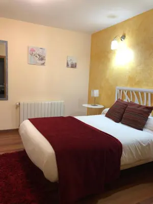 a bedroom with a large bed with a red blanket at Hotel gela in El Puente