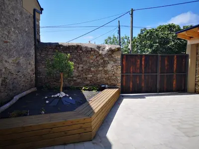 a garden with a wooden fence and a tree at La Isla de Próspero in Tapia de Casariego
