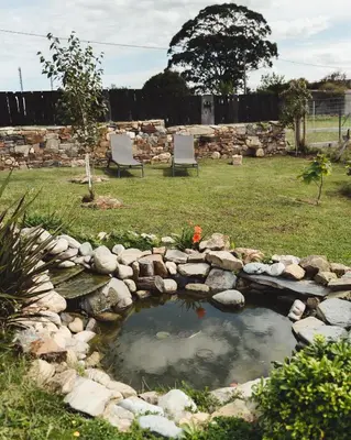 a pond with two chairs in a yard at La Isla de Próspero in Tapia de Casariego