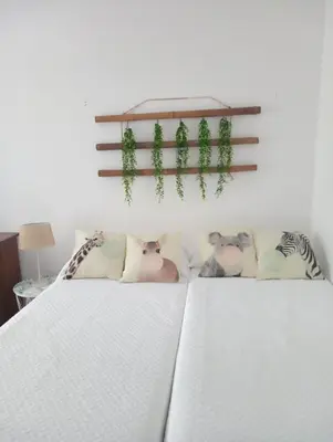 a bedroom with two beds with plants on the wall at Apartamentos CASA AMELIA in Padrón
