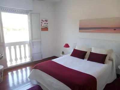 a bedroom with a large bed and a window at Apartamentos CASA AMELIA in Padrón