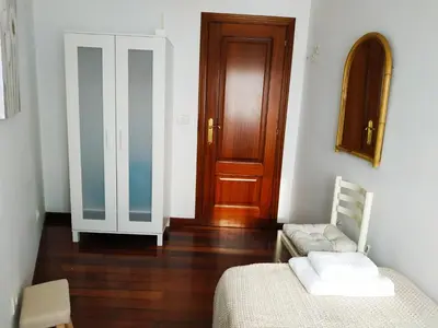 a room with a bed and a wooden door at Apartamentos CASA AMELIA in Padrón