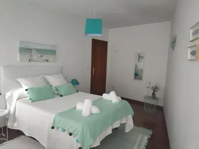 a bedroom with a bed with two towels on it at Apartamentos CASA AMELIA in Padrón