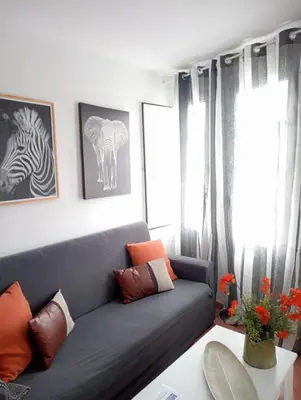 a living room with a blue couch and some windows at Apartamentos CASA AMELIA in Padrón