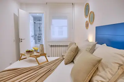 a dining room and living room with a table and a couch at Apartamento San Pedro in Santiago de Compostela