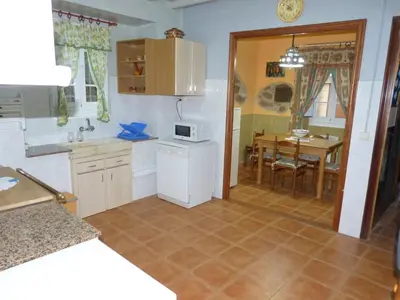 a kitchen with a table and a microwave at Casa Cástor O Valadouro Galicia in Alaje