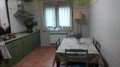 a kitchen with a table and a sink and a table and chairs at En plena Ribera Sacra CasaCocó in Ferreira de Panton